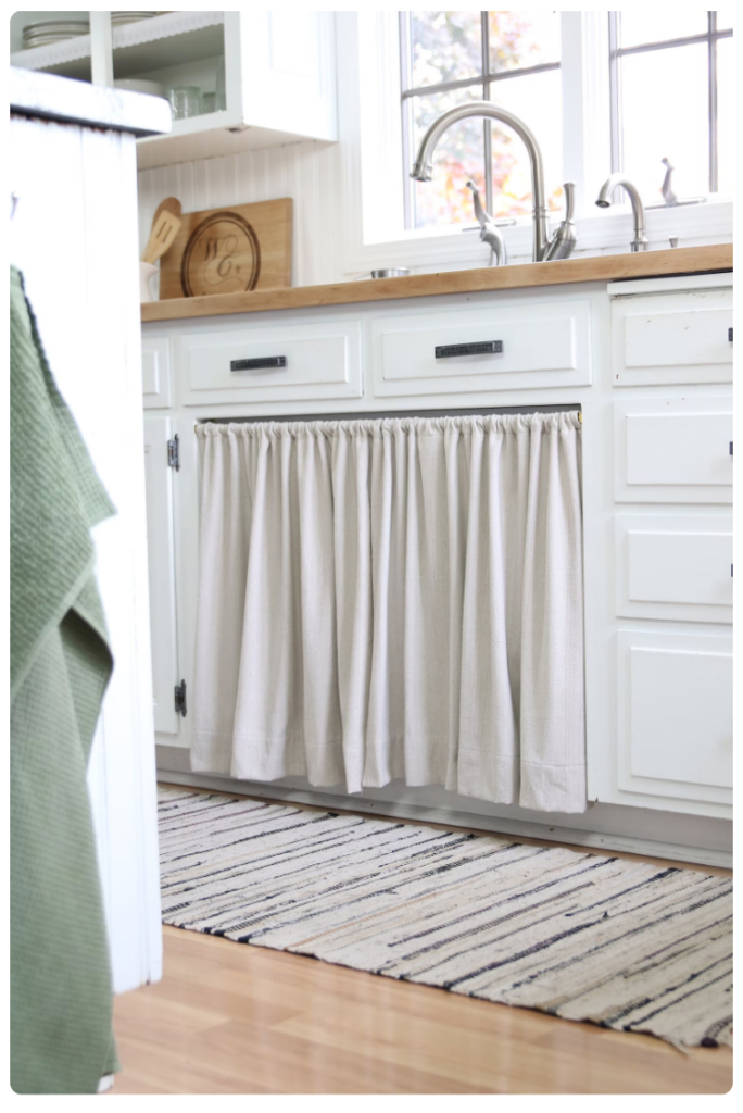 White cabinets with a small curtain under the sink